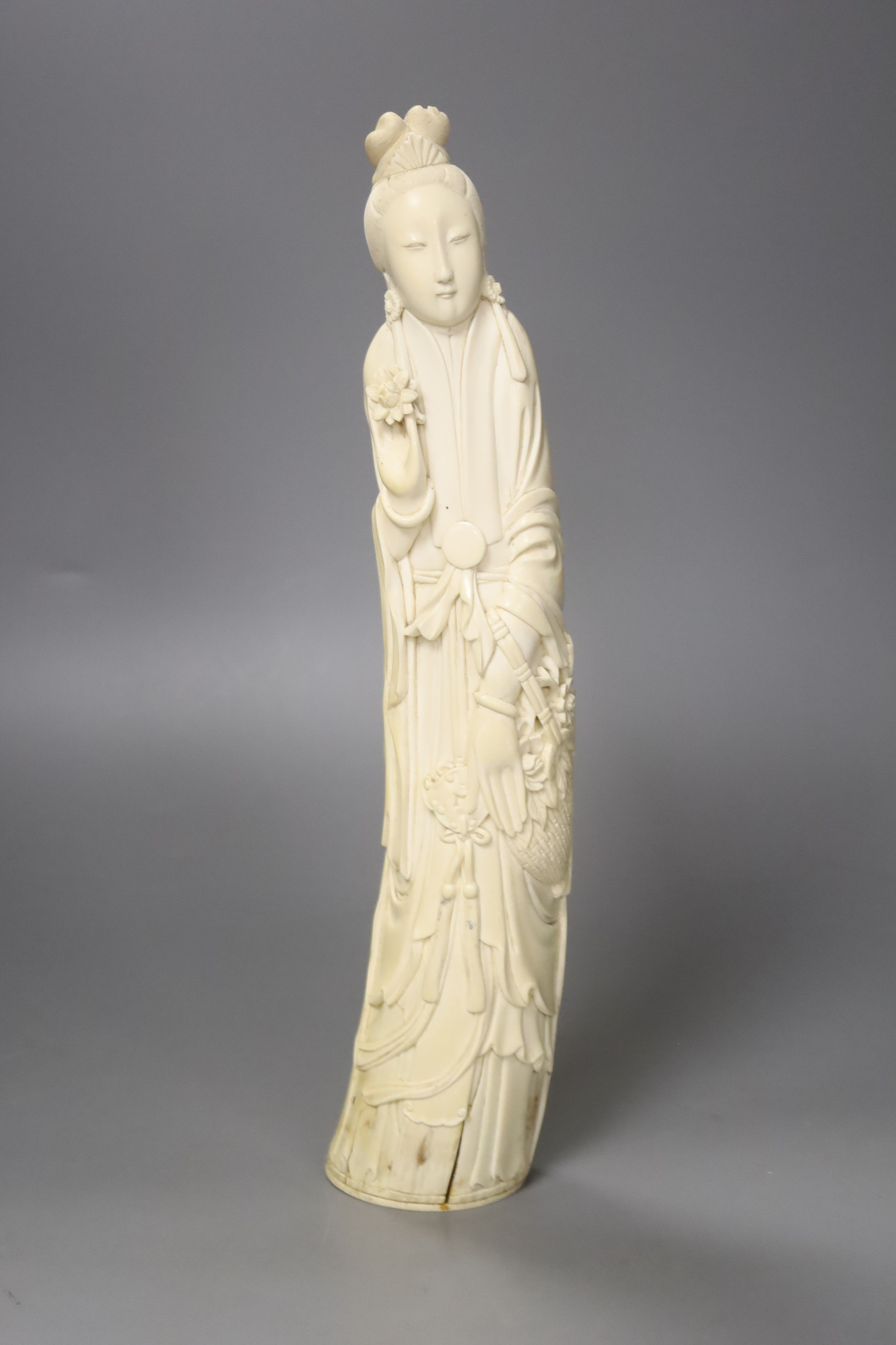 A Chinese ivory carving of a He Xiangu, early 20th century, height 34cm